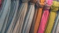 Fabrics of different colors and textures hang vertically. Royalty Free Stock Photo