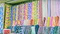 Traditional fabric store with stacks of colorful textiles, fabric rolls at market stall - textile industry background with blurred Royalty Free Stock Photo