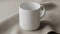 Fabric surface. The mug is cylindrical with a smooth surface and a Royalty Free Stock Photo