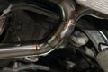 Fabrication and installation of a stainless steel car exhaust pipe with a bifurcation and a louder sound with a color weld under Royalty Free Stock Photo