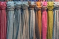 Fabrics of different colors and textures hang vertically. Royalty Free Stock Photo