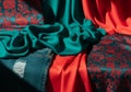 Turquoise and red satin materials, with intricate floral patterns Royalty Free Stock Photo