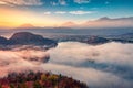 Fabulous autumn sunrise on Bled lake. Foggy morning view of Bled Castle.