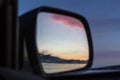 A fabulous beautiful pink sunset reflected in the mirror of a distant view of the car on Lake Baikal in winter. Royalty Free Stock Photo