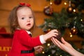 Fabulous Christmas holidays mom and daughter in red dresses decorate the Christmas tree. Cozy family holiday Royalty Free Stock Photo