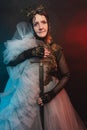 A fabulous creature, a historical character, a fantasy queen, a witch, in a fabulous costume with a sword in her hands. Woman, mod Royalty Free Stock Photo