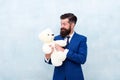 Fabulous gift for little ones. Bearded man hold teddy bear. Businessman with toy gift blue background. Happy boxing day