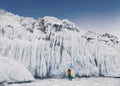 Fabulous ice icicles on the rocks of lake Baikal. Tourist photographs the icy rocks. Eastern Siberia