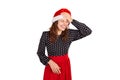 Fabulous joyful woman showing tongue and looking down laughs put hand on forehead. emotional girl in santa claus christmas hat iso