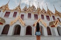 Fabulous, mystical, Buddhist Asian temple with pagodas and statues. Woman impressed with the beauty of the place