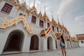 Fabulous, mystical, Buddhist Asian temple with pagodas and statues. Woman impressed with the beauty of the place