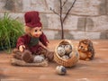 Fabulous picture with small toys. Hedgehog and Lesovik rest in the forest. They carry a large basket of quail eggs