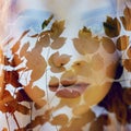 Fabulous portrait of a red-haired girl in nature with double exposure and glare. Beautiful redhead girl with long hair in forest