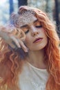 Fabulous portrait of a red-haired girl in nature with double exposure and glare. Beautiful redhead girl with long hair in forest Royalty Free Stock Photo