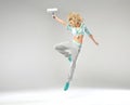Fabulous shapely girl jumping with paint roller