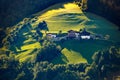 Fabulous sunlit landscape with green meadows, trees and typical buildings of the Alps