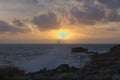 Fabulous sunset on the beach. Sea is stormy. Wave is breaking on rocks. Royalty Free Stock Photo