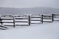 Fresh snow filled corral fences at rural winter snowy horse farm