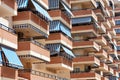 Facade of apartment building with balconies and awnings from the sun. Royalty Free Stock Photo