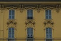 Facade of the baroque yellow building with windows and blue shutters in old town. Historical architecture Royalty Free Stock Photo
