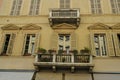 Facade of the baroque yellow building with windows and shutters, balcony with plants in the center. Royalty Free Stock Photo