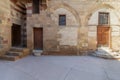 Facade Mamluk era historic building with grunge stone bricks wall and grunge wooden doors, Darb al Ahmar District, Cairo, Egypt