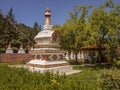 Facade of a beautiful colorful Buddhist temple with green trees and tourists