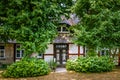 Facade of a beautiful vicarage with a thatched roof in a small village surrounded by green trees