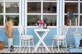 Facade blue Cozy home with a beautiful garden in summer. Beautiful farmhouse with wicker baskets and green plants on terrace. Whit Royalty Free Stock Photo