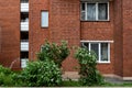 Facade of a brick building with windows and balconies trees grow nearby Royalty Free Stock Photo