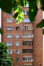 Facade of a brick building with windows and balconies trees grow nearby Royalty Free Stock Photo