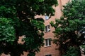 Facade of a brick building with windows and balconies trees grow nearby Royalty Free Stock Photo