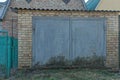 Facade of a brown brick garage with gray iron dirty gates