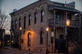 Facade of the brown building in the evening illuminated by street lamps.