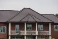 Facade of a brown private brick house with a white concrete balcony Royalty Free Stock Photo