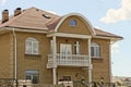 facade of a brown private brick house with a white concrete balcony