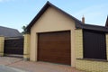 Facade of a brown private garage and a fence