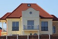 Facade of a brown private house with a gray open concrete balcony Royalty Free Stock Photo