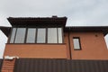 Facade of a brown private house with a large glassed in balcony Royalty Free Stock Photo