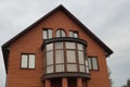 Facade of a brown private house with a large glassed in balcony Royalty Free Stock Photo