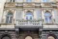 Facade of a building with ancient architecture with windows and a balcony terrace with columns, patterns and symbols on one of the Royalty Free Stock Photo