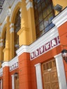 The facade of the building of the Drama Theater. Pilasters are painted white. Walls freshly painted in yellow and orange. Satyr