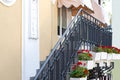 Facade of building with an external staircase with black railing and stucco on the wall.