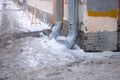 A snow-covered city sidewalk is protected from falling icicles by warning tape Royalty Free Stock Photo