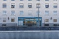 Facade of a building with many square windows and a large metal portal painted blue Royalty Free Stock Photo