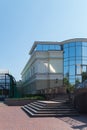 The facade of the building with wide steps of the staircase leading to the entrance with mirrored glass. Royalty Free Stock Photo