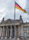 The Bundestag Reichstag Parliament Building and the german flag in the foreground, Berlin, Germany. Royalty Free Stock Photo