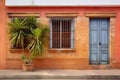 facade of a colonial house with wooden door, brick walls