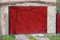 Facade of a concrete gray garage with red iron gates