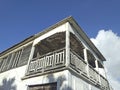 Facade corner of Caribbean building under tropical blue sky. Colonial run down house typical of the French West Indies. Royalty Free Stock Photo